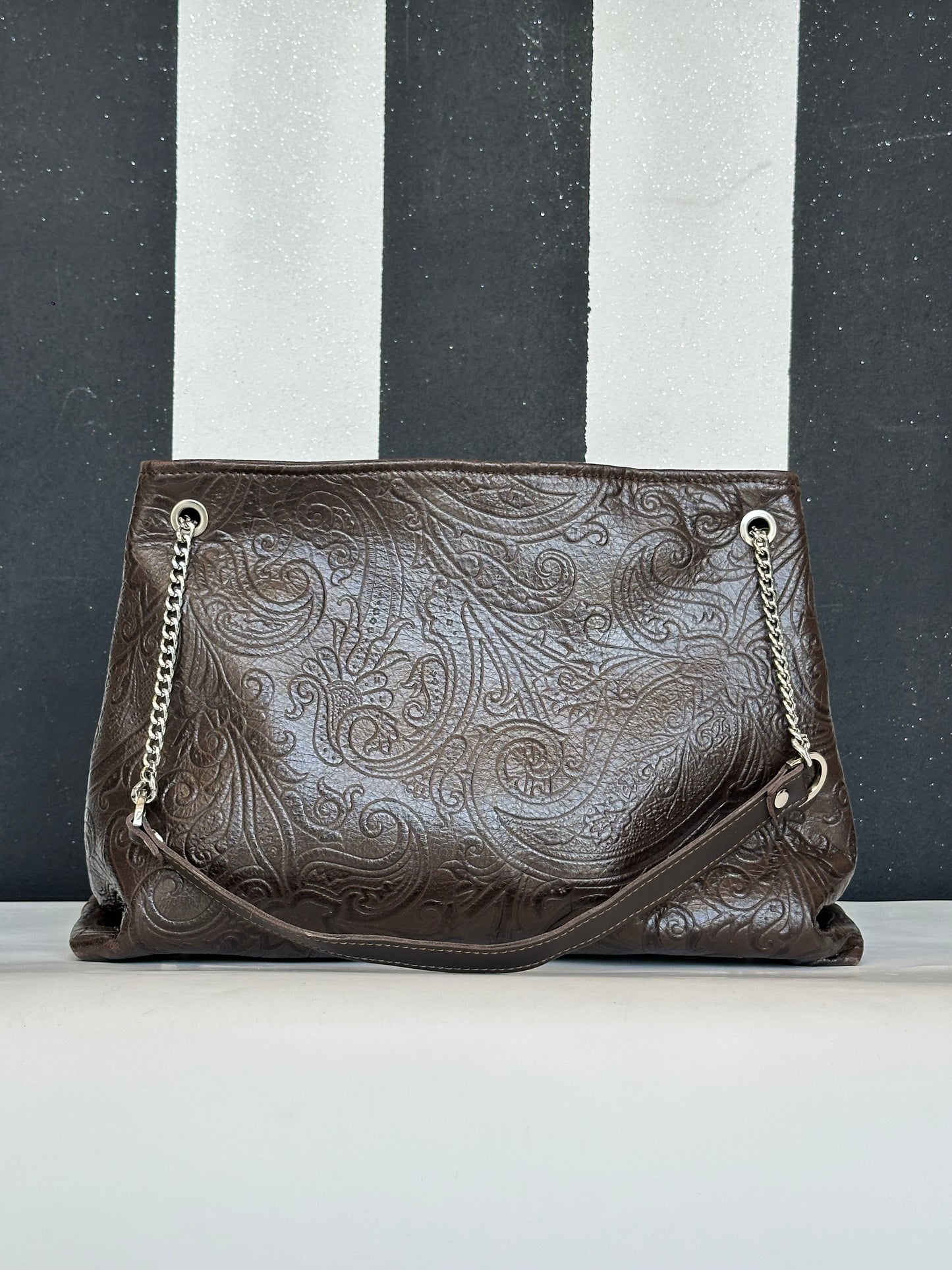 Borsa artigianale a spalla e tracolla in vera pelle ricamata con fantasia floreale e di colore marrone scuro. Modello Ismi di Nany Magenis